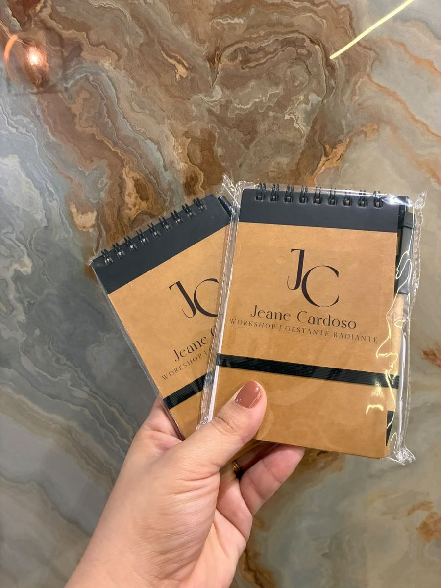 Cadernetas kraft personalizadas com a marca de uma consultoria, embaladas com caneta