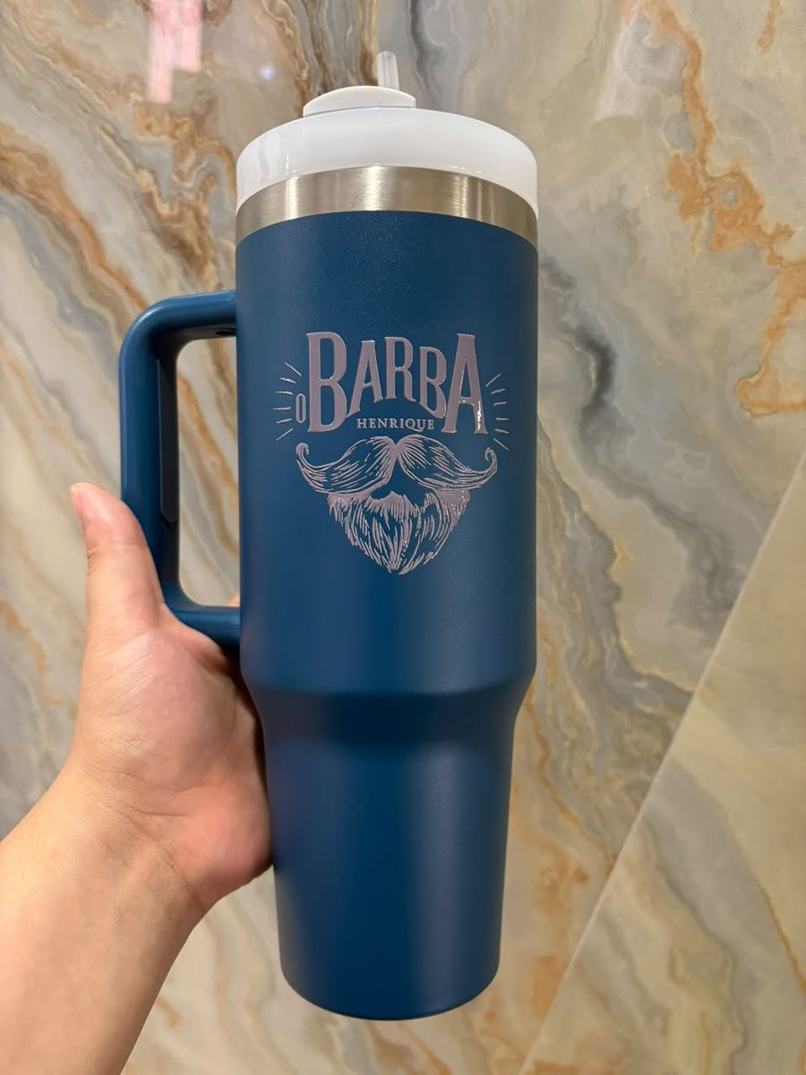Copo térmico azul com alça, com a marca de uma barbearia gravada a laser