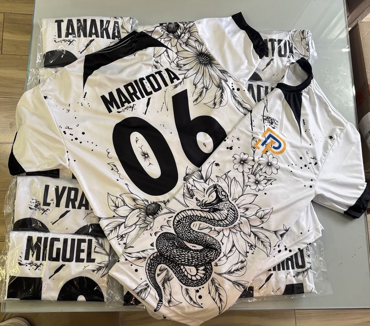 Camisetas brancas de interclasse sublimadas com arte de flores e cobra, nome e número de cada aluno